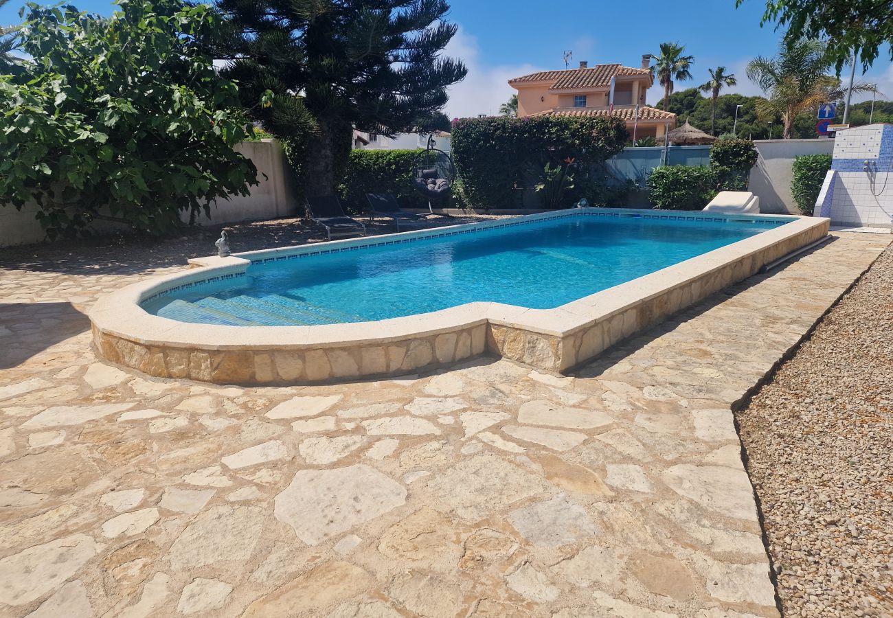 Piscina azul rodeada de un jardín frondoso con vistosas plantas de buganvilla en Casa Cologne