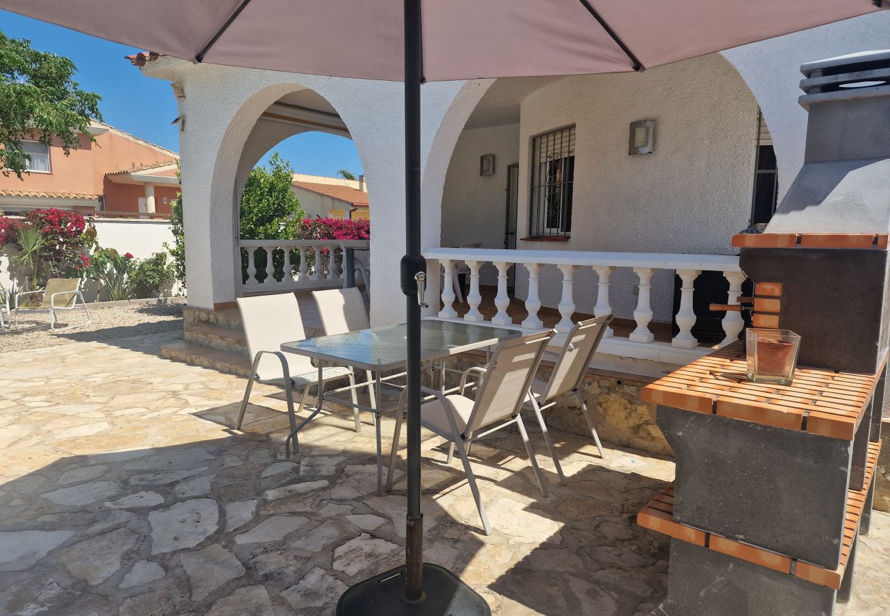 Vistas de la acogedora terraza cubierta y la zona de barbacoa completa de la villa vacacional.
