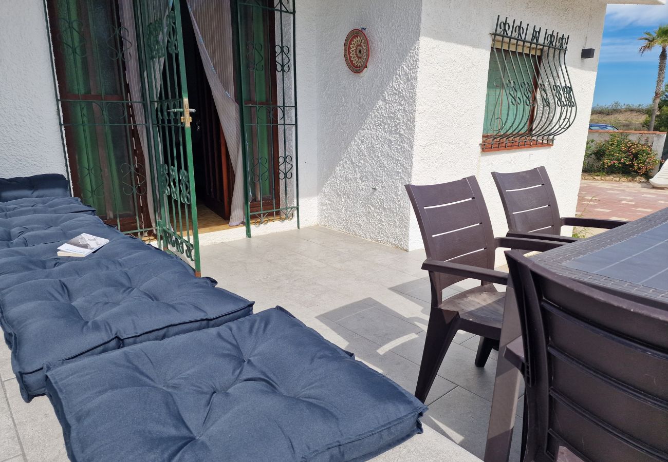 Terraza moderna con un banco integrado justo al lado de la acogedora entrada de la casa.