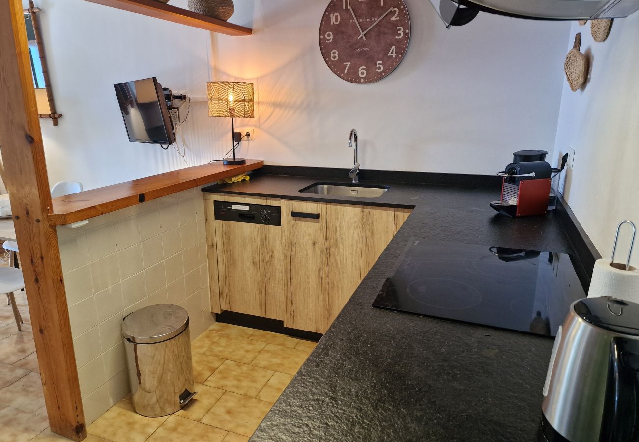 Encimera de cocina moderna con una cafetera de cápsulas y un lavavajillas integrado.