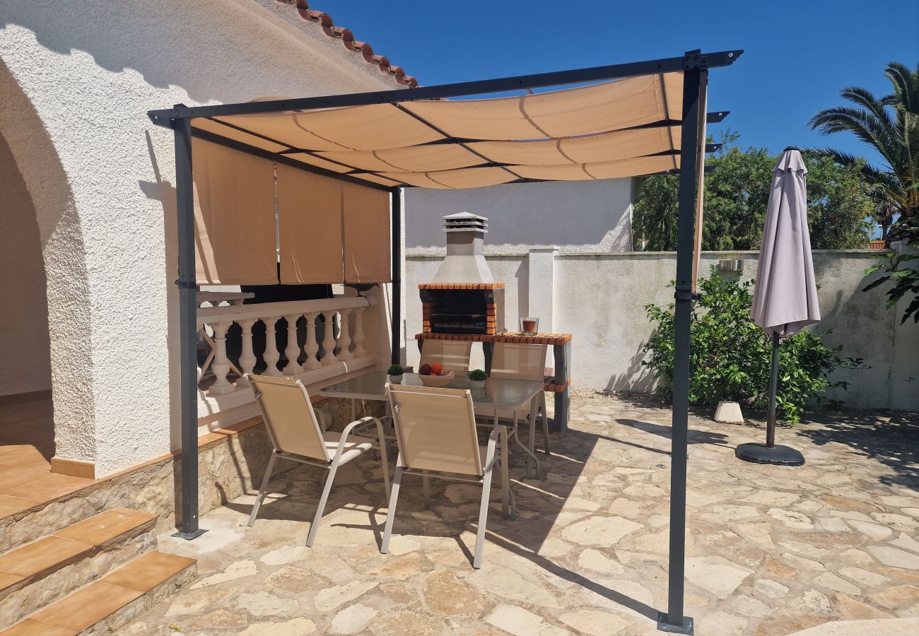 Vue sur la terrasse inférieure ombragée par une pergola avec un barbecue à la maison Cologne.