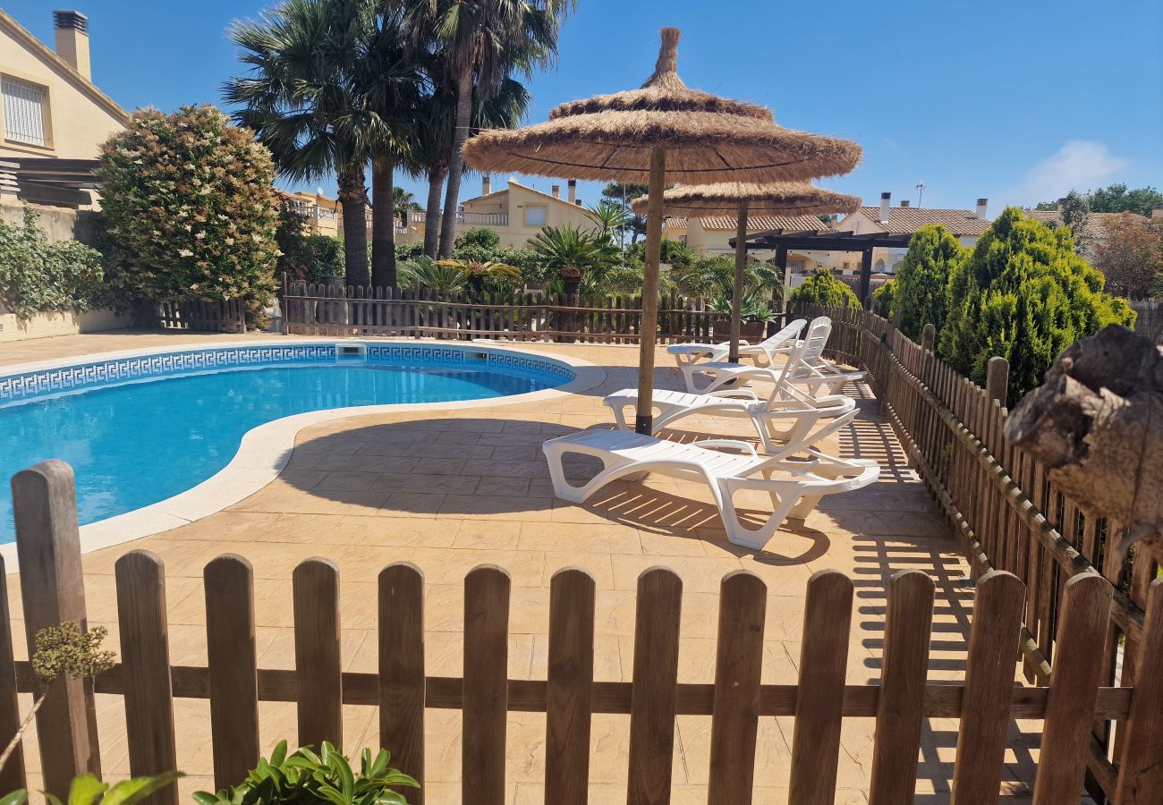 Vue depuis la terrasse sur la grande piscine privée et le jardin de la maison de vacances Eva.