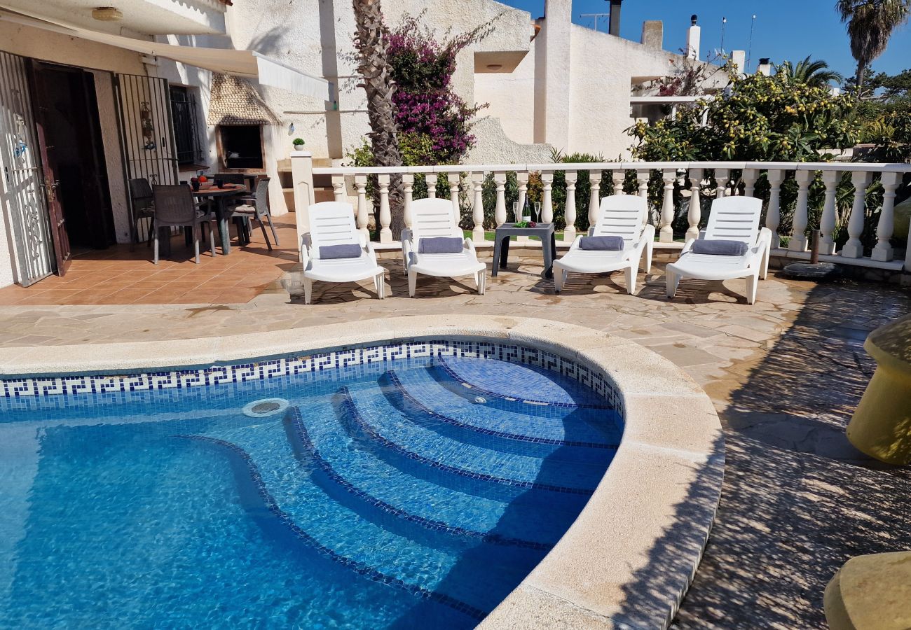 „Plage de piscine ensoleillée avec terrasse couverte.“