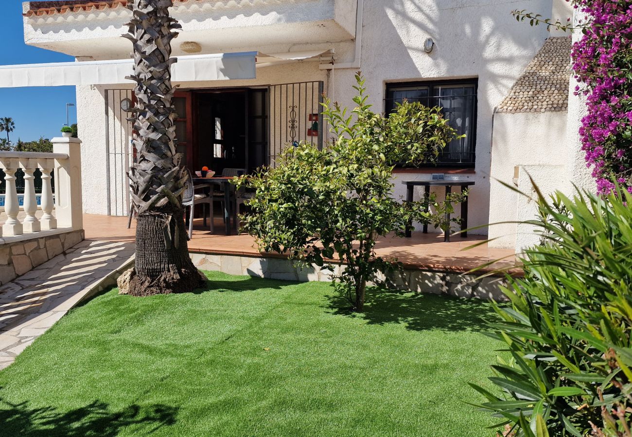 „Vue du jardin sur la terrasse avec store banne ouvert.“