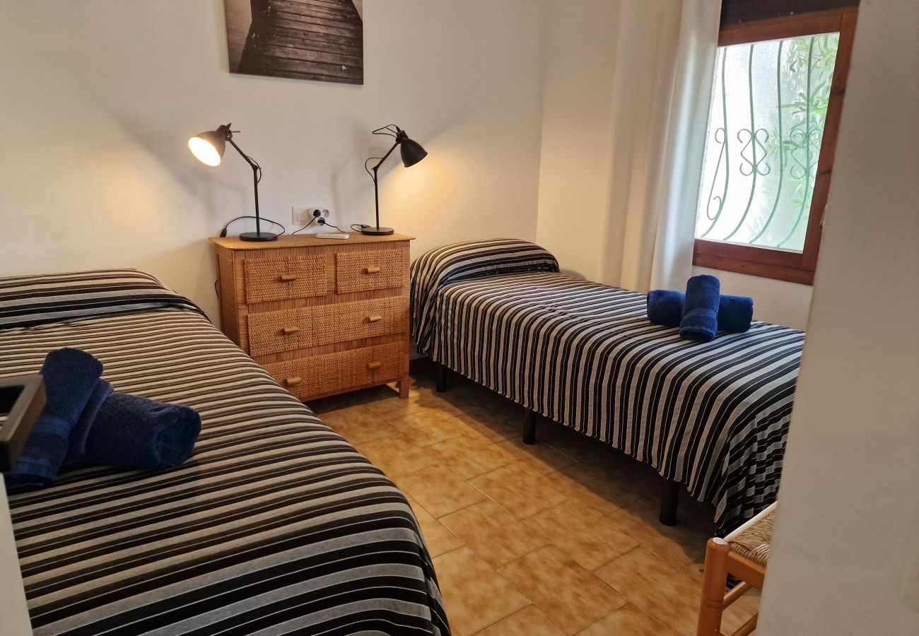 Chambre lumineuse avec deux lits simples séparés et un climatiseur moderne installé au mur.