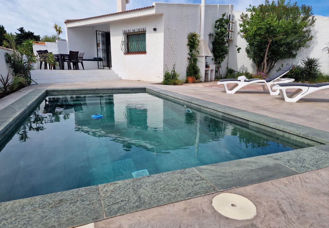 Terrasse de piscine moderne avec des chaises longues confortables et un deck en bois.
